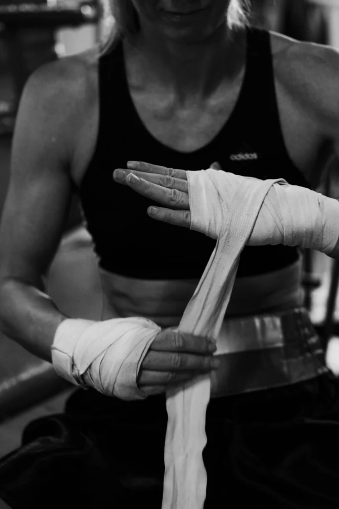 Close-up of a woman wrapping her hands before a cancer coaching session.